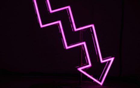 Neon pink arrow that zigzags down and to the right